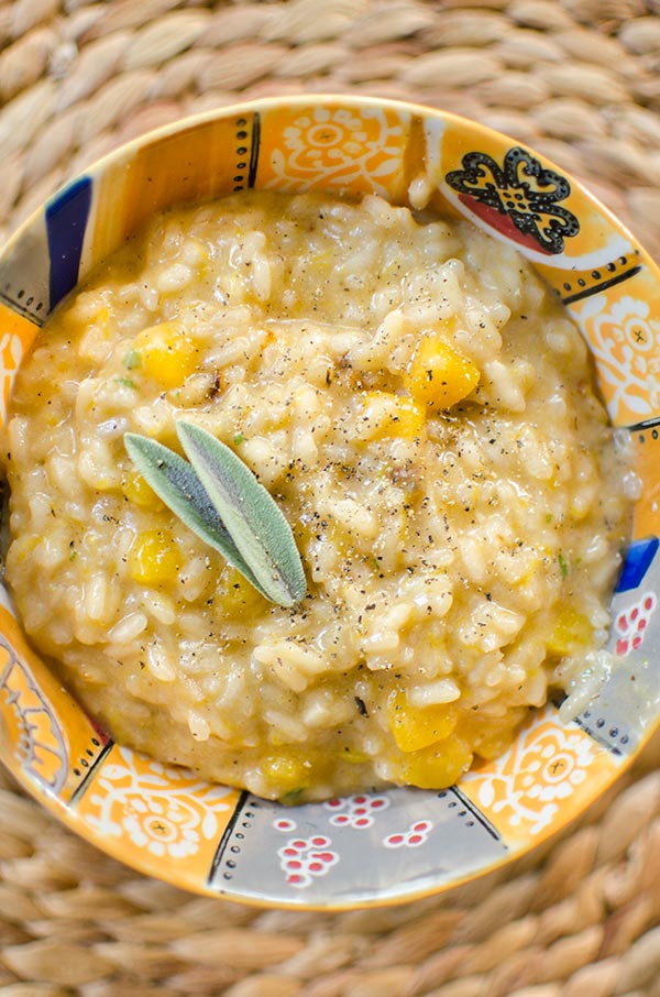 Butternut squash risotto in a colourful bowl with a fresh sage garnish.