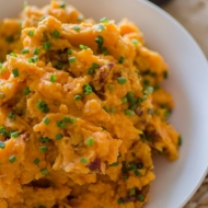 Buttermilk blue cheese mashed potatoes in a white bowl with chives sprinkled on top