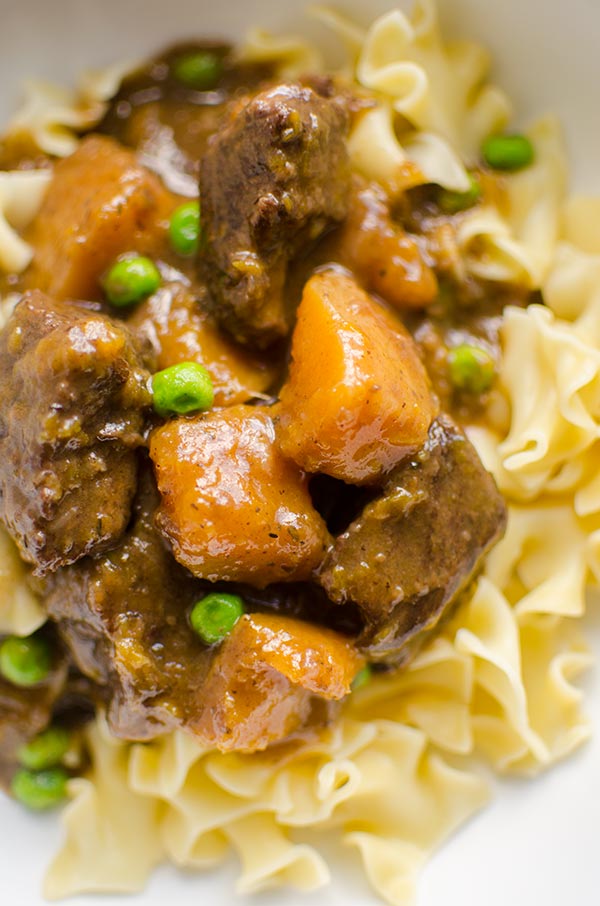 Make the perfect melt in your mouth and tender beef and butternut squash stew, made with stewing beef, butternut squash and peas. | livinglou.com