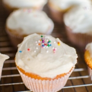 Closeup of vanilla cupcake with vanilla frosting and sprinkles