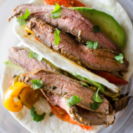 Plated flank steak fajitas with cilantro and avocado