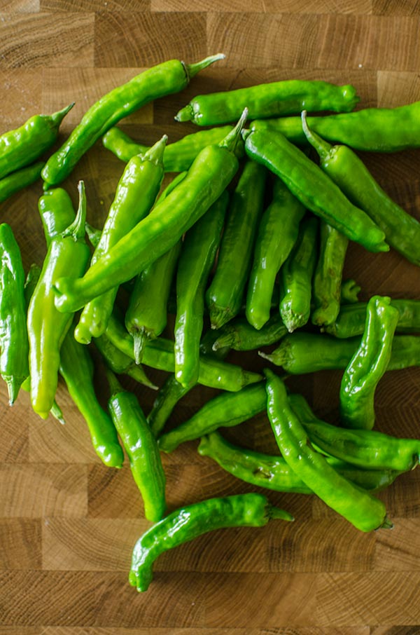 Shishito peppers on a cutting board.