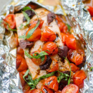 Grilled salmon in foil with cherry tomatoe, kalamata olives, basil and drizzled with balsamic glaze.