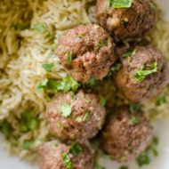 Korean meatballs on jasmine rice in a bowl with cilantro sprinkled on top.