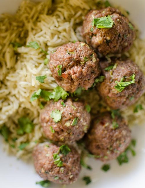 Korean meatballs on jasmine rice in a bowl with cilantro sprinkled on top.