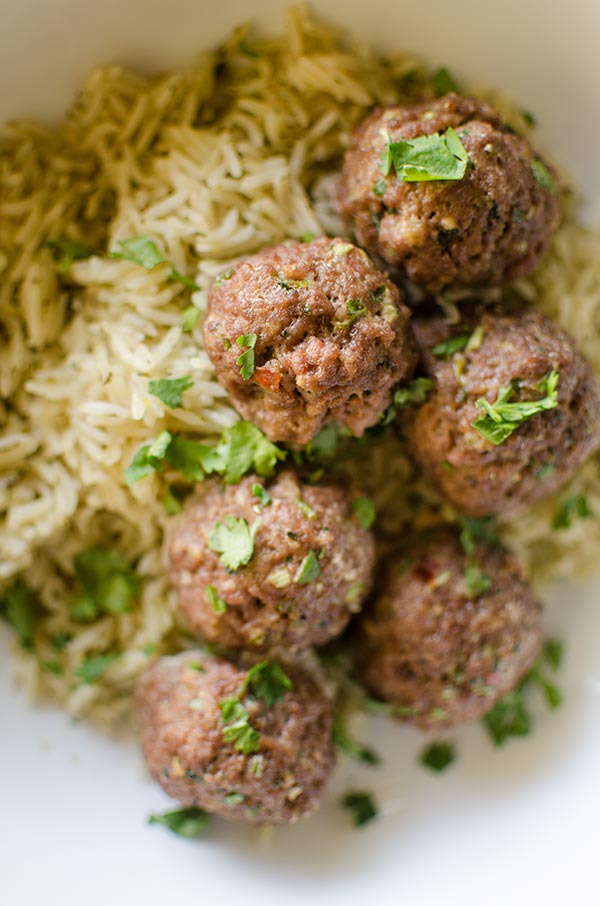 Korean meatballs on jasmine rice in a bowl with cilantro sprinkled on top.