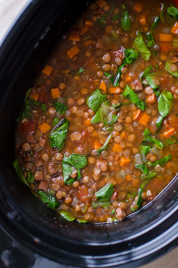 Slow cooker filled with cooked lentil and ham soup