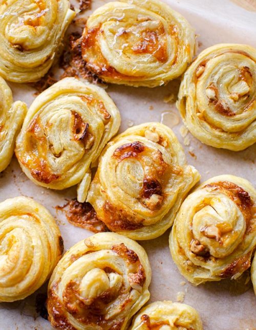 Close up of baked puff pastry brie bites on a baking sheet.