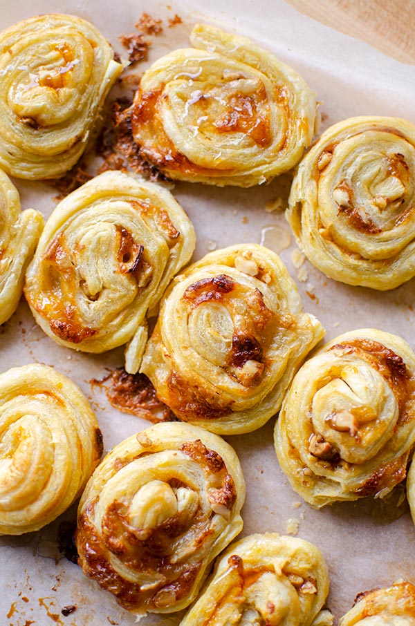 Close up of baked puff pastry brie bites on a baking sheet.