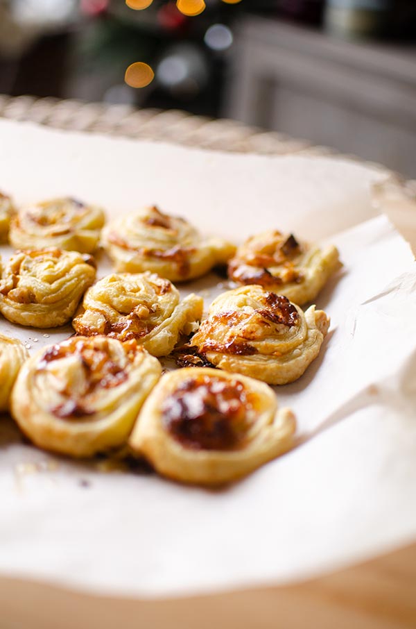 Side angle of puff pastry brie bites with Christmas tree in the background