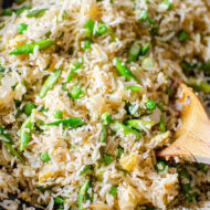 A spoonful of asparagus fried rice in a wok.