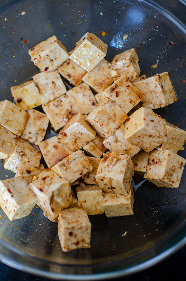 Tofu marinating in a glass bowl.
