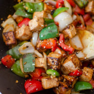 Tofu bell pepper stir fry in a wok.