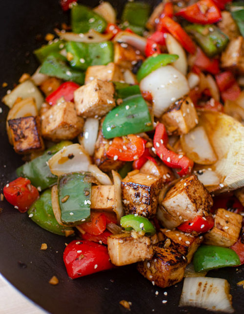 Tofu bell pepper stir fry in a wok.