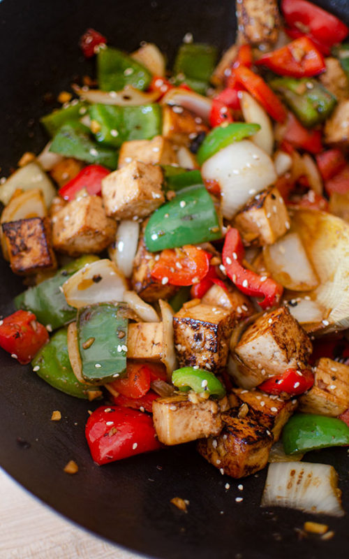 Tofu bell pepper stir fry in a wok.