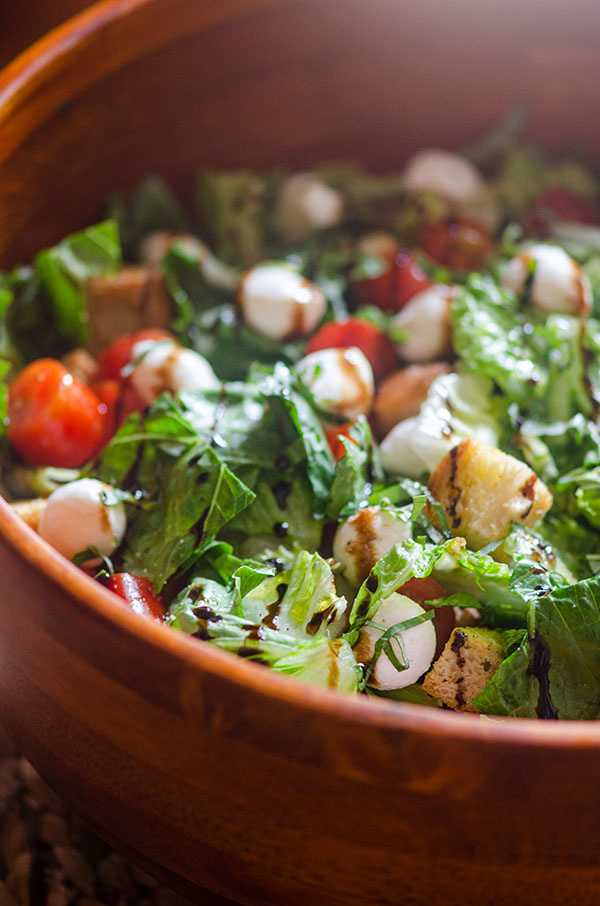 Macro closeup of bruschetta salad in a wooden salad bowl.