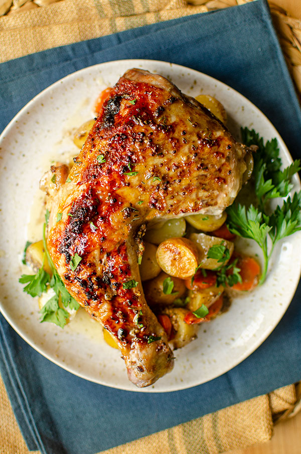 Serving of chicken leg with potatoes on a plate