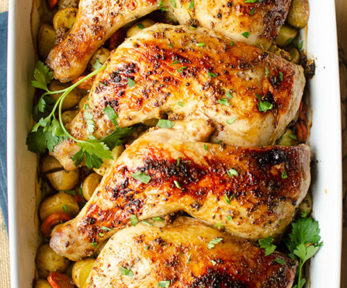 Chicken leg quarters in a 9x14 dish with potatoes and parsley