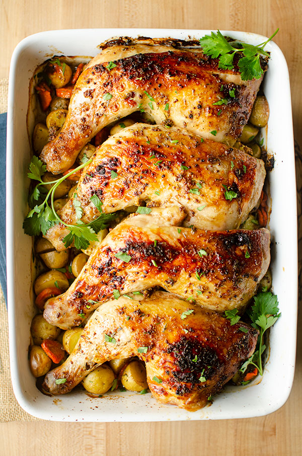 Chicken leg quarters in a 9x14 dish with potatoes and parsley