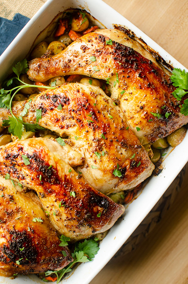 Closeup of cooked chicken quarters in a baking dish