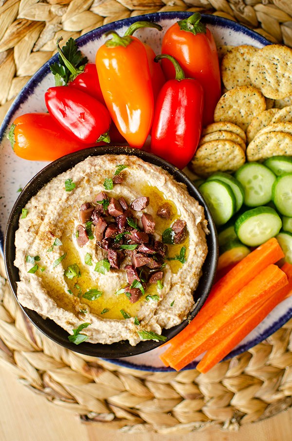 Top down shot of olive hummus in a serving platter.