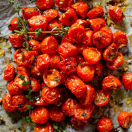 Roasted cherry tomatoes in a pile on a baking sheet