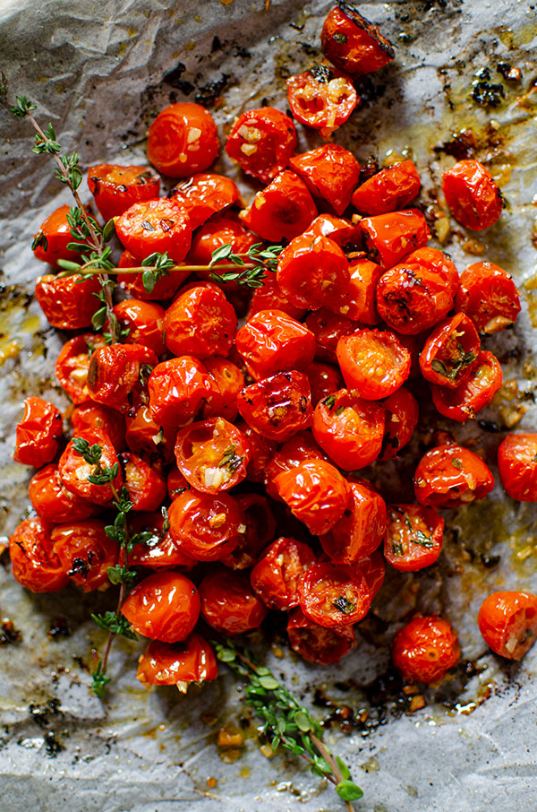 Roasted cherry tomatoes in a pile on a baking sheet