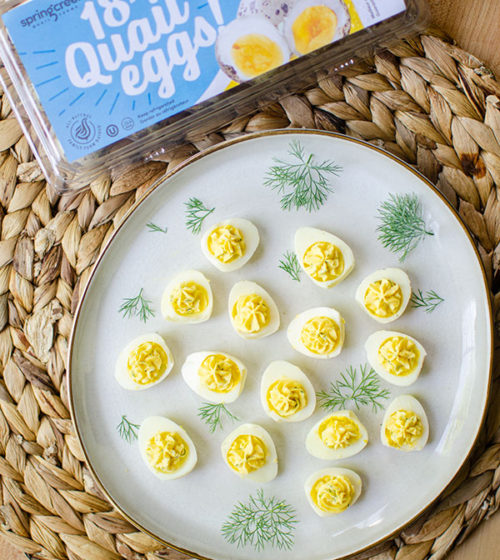 plate of deviled quail eggs with spring creek carton