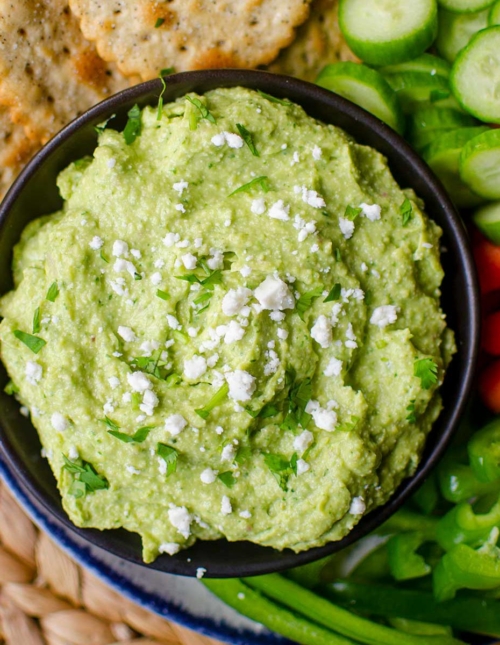 Dip in a black bowl with crackers and crudites