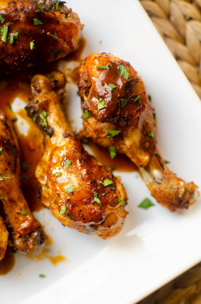 Plated chicken legs with gravy and parsley.