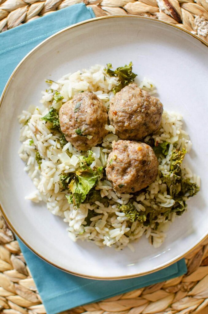 A serving of the rice and meatballs on a white plate.