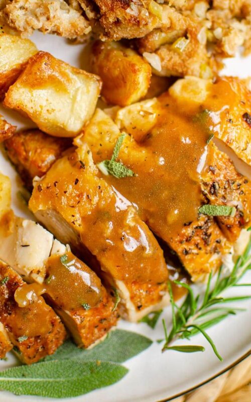 Closeup of chicken with gravy, potatoes and stuffing.