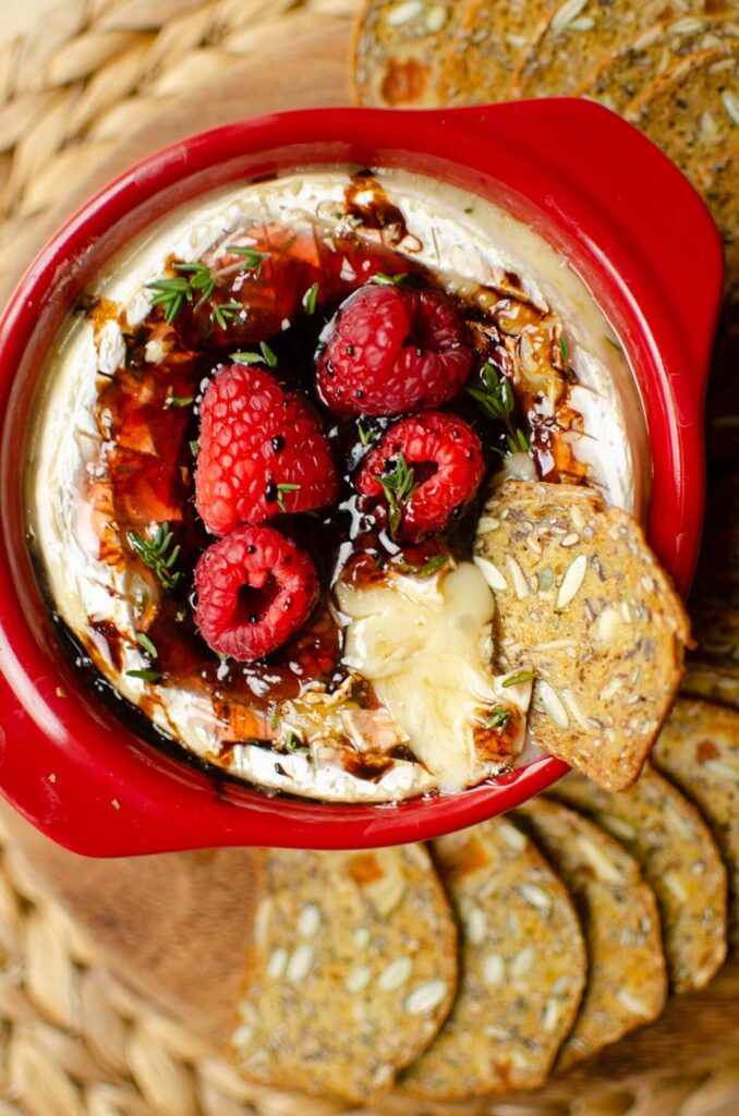 A cracker in melted baked brie.