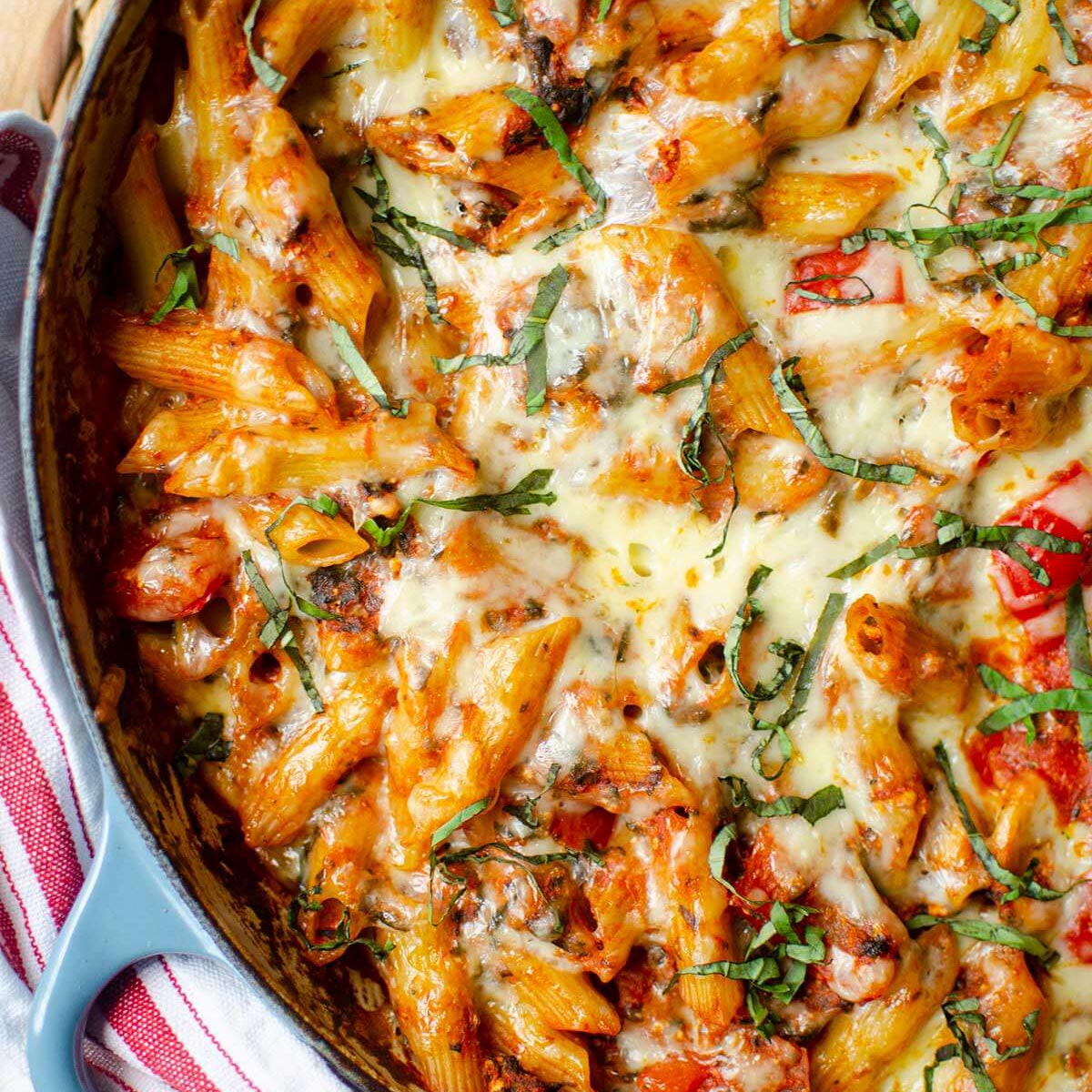 Closeup of baked ziti in blue dish.