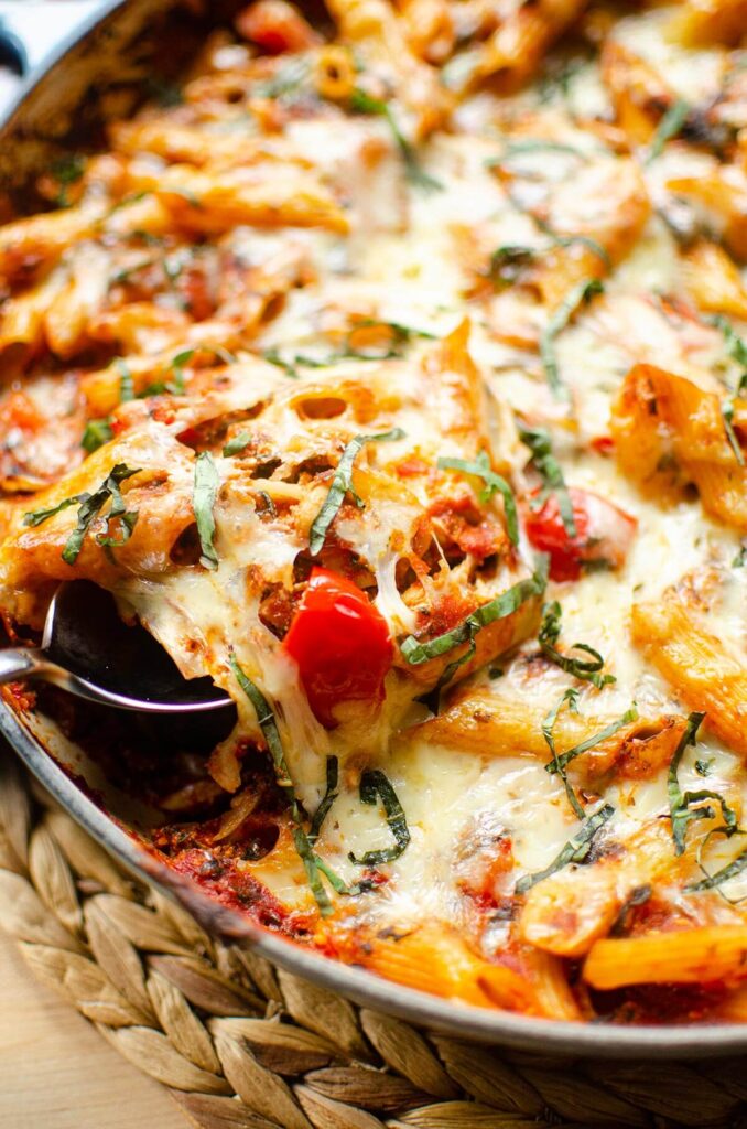 Closeup of a serving being taken out of the baked pasta serving dish.