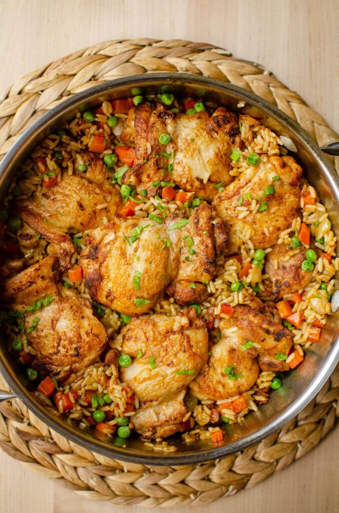 Cooked chicken and rice in a pot with parsley on top.