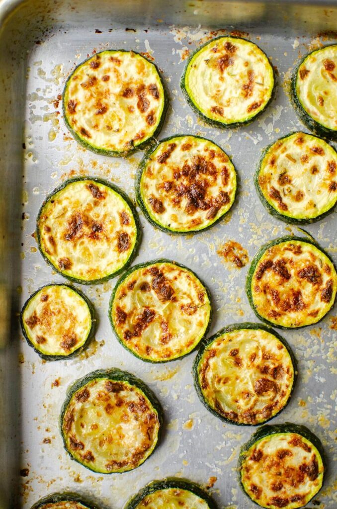 Baked zucchini slices on a baking sheet.
