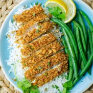 Closeup of a plate of chicken with rice and green beans.