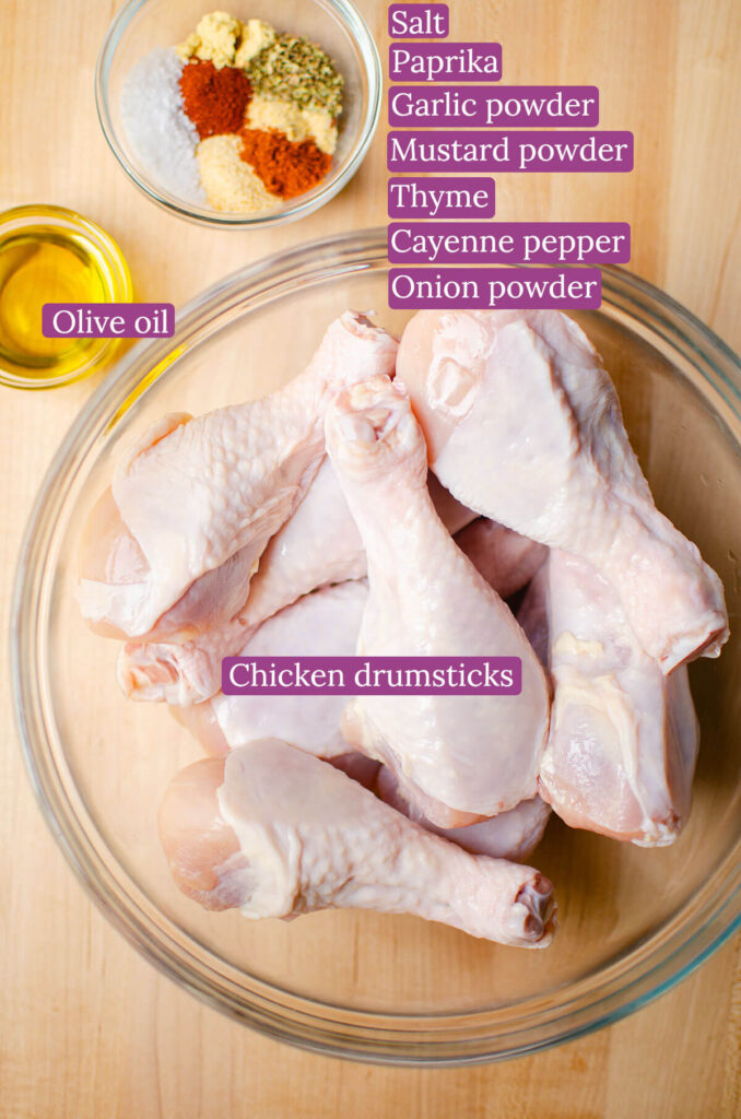 Ingredients for chicken drumsticks on a wooden board.
