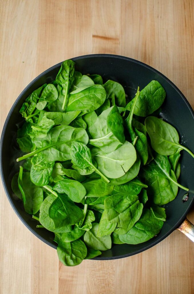 Raw spinach in a frying pan.