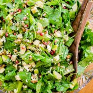 Closeup of salad in a crystal bowl with wooden salad spoons