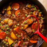 Closeup of a ladle in finished beef stew.