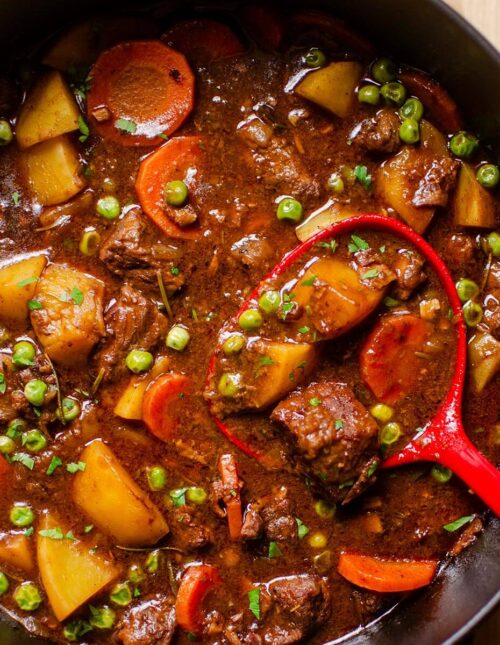 Closeup of a ladle in finished beef stew.