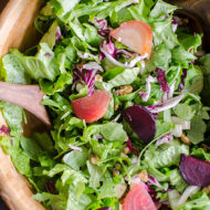 Salad with arugula, romaine, radicchio and roasted beets in a wooden bowl.